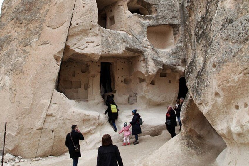 A group of people exploring a cave with ancient rock carvings. 2