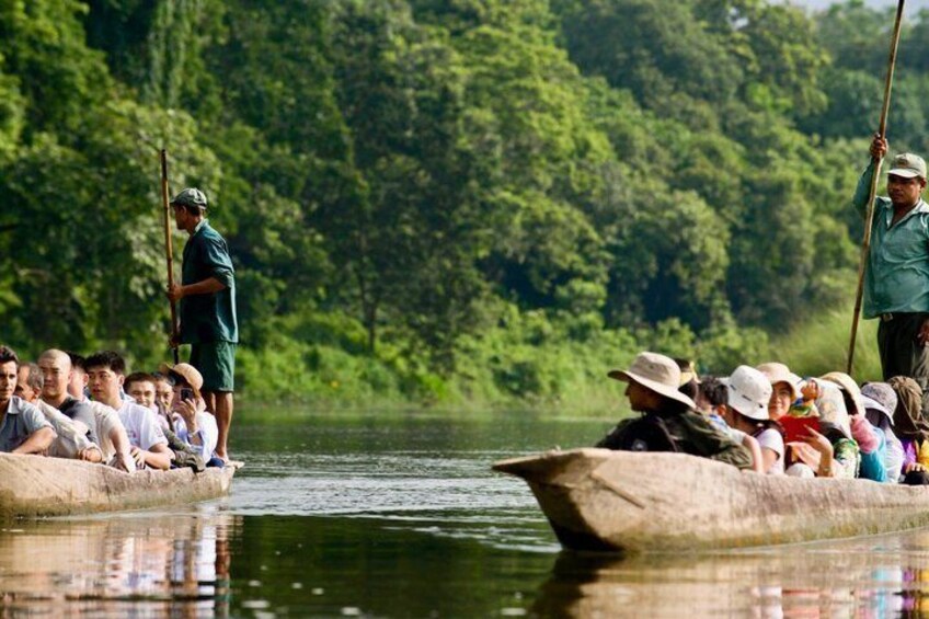 A group of people on a boat, surrounded by a forested riverbank. 5