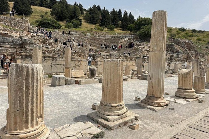 Ancient stone columns and ruins of a theater with visitors in the background. 5