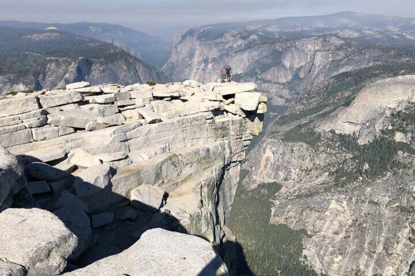 A rocky cliff edge with a person standing at the top. 5