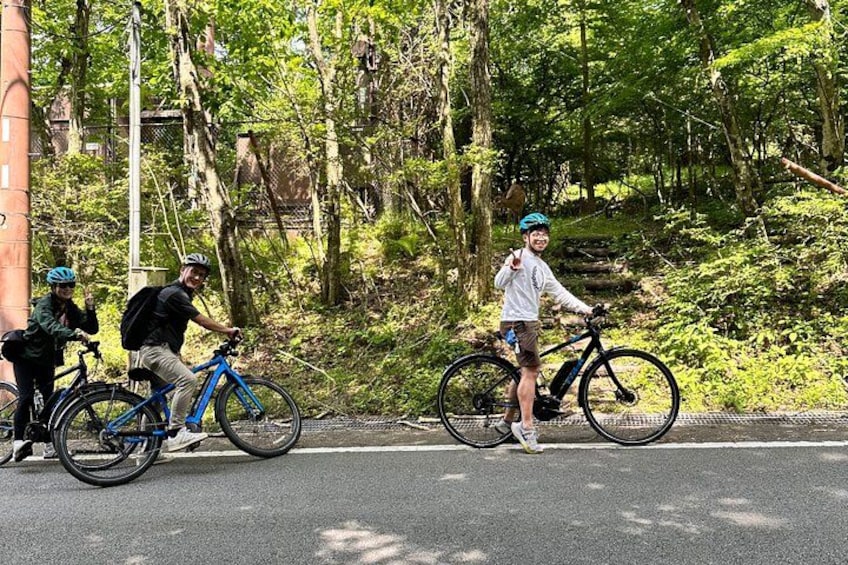A group of cyclists on a paved path surrounded by dense greenery. 5