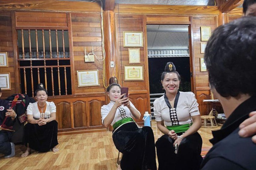 A group of people in a wooden room with framed certificates on the walls. 3