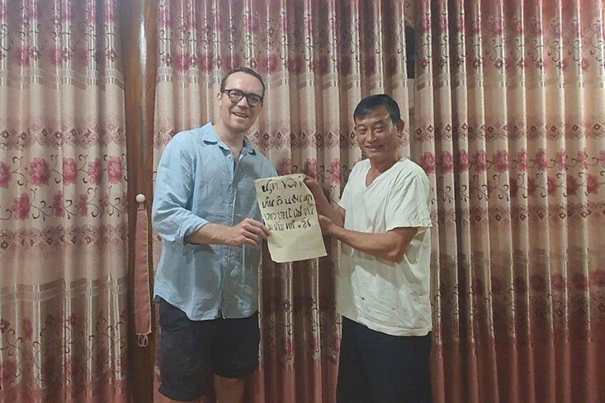 Two people holding a sign with text. 2