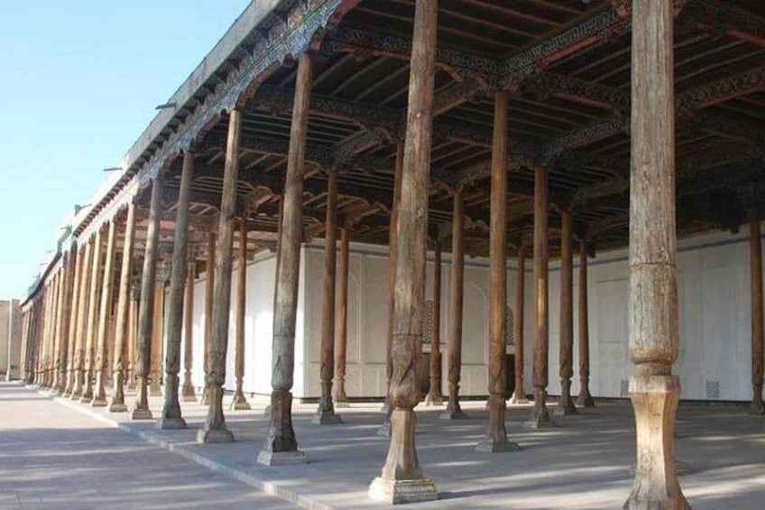 A series of wooden columns supporting a roofed structure. 3