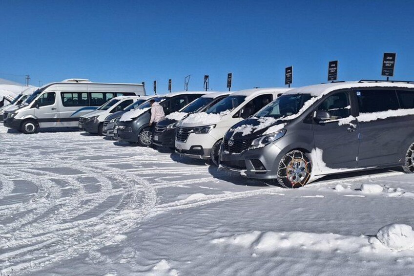 A line of parked cars covered in snow. 3