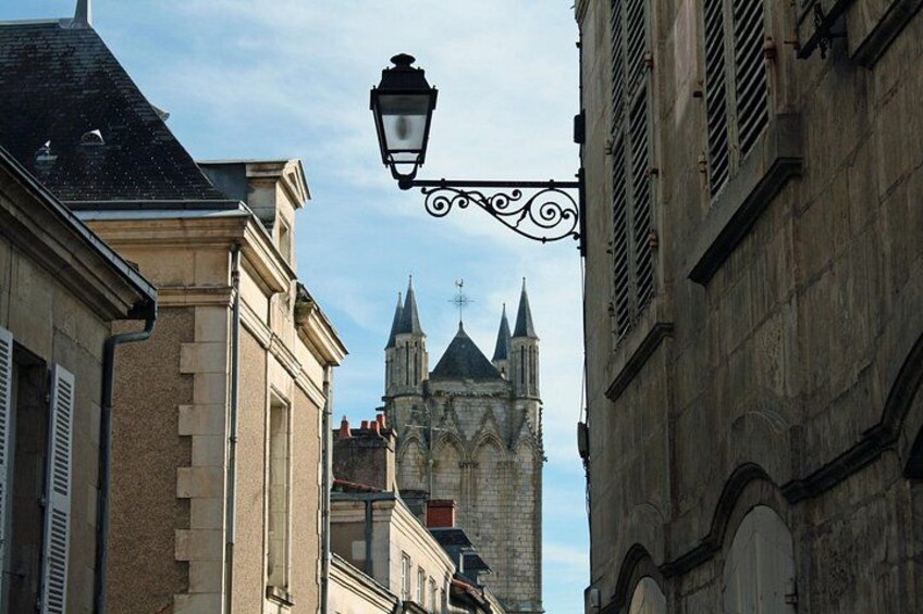 Eine Straße mit Gebäuden, einer Straßenlaterne und einem Kirchturm. 5