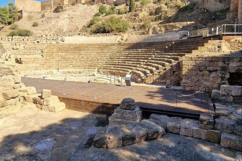 An ancient amphitheater with stone seating and a stage area. 4
