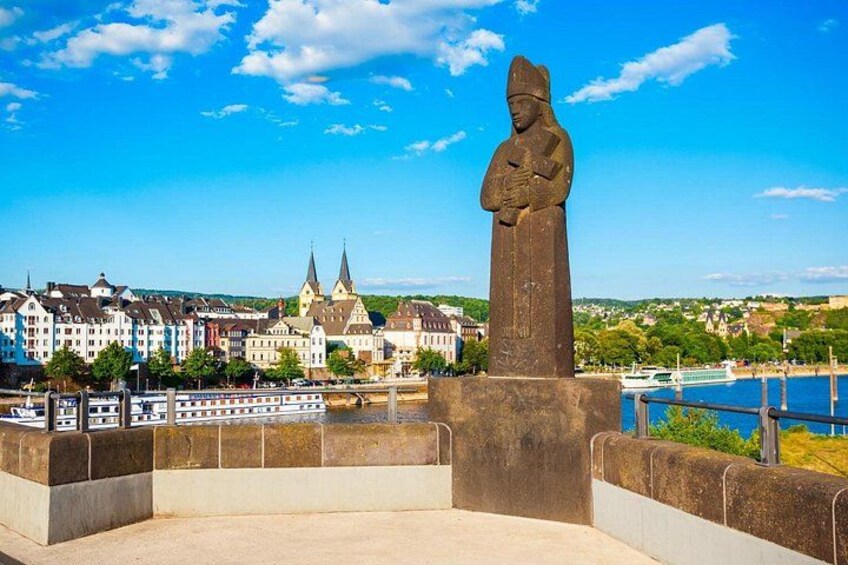A statue, a river, and a town with buildings and a church. 4