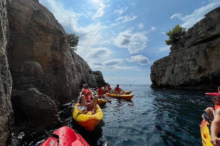 Des personnes pratiquent le kayak sur une rivière, entre de hautes falaises rocheuses. 2