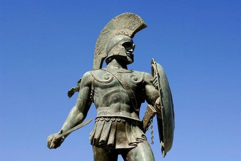 A bronze statue of a warrior with a helmet, shield, and spear. 1