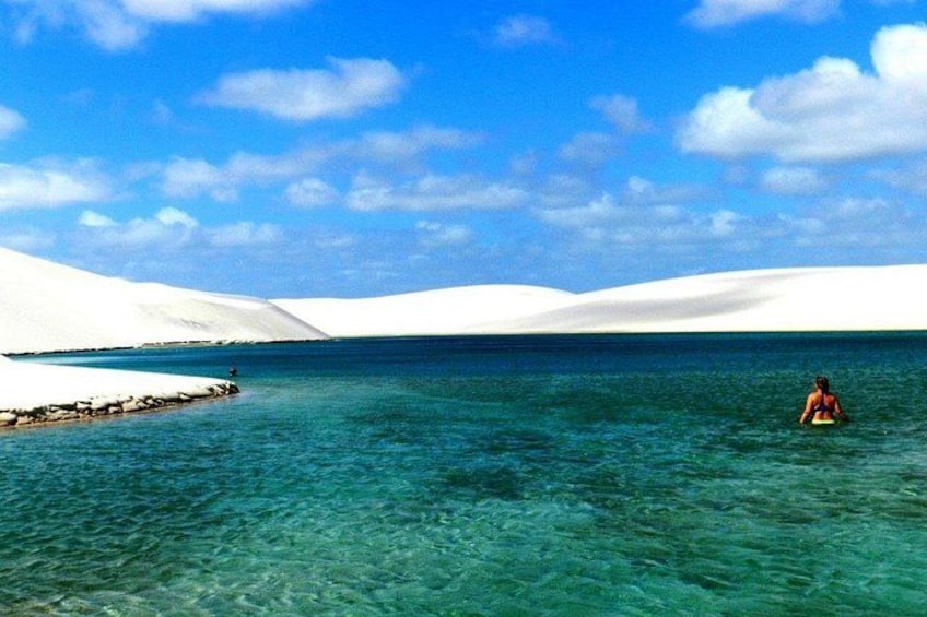 A desert landscape with sand dunes and a clear blue sea. 3