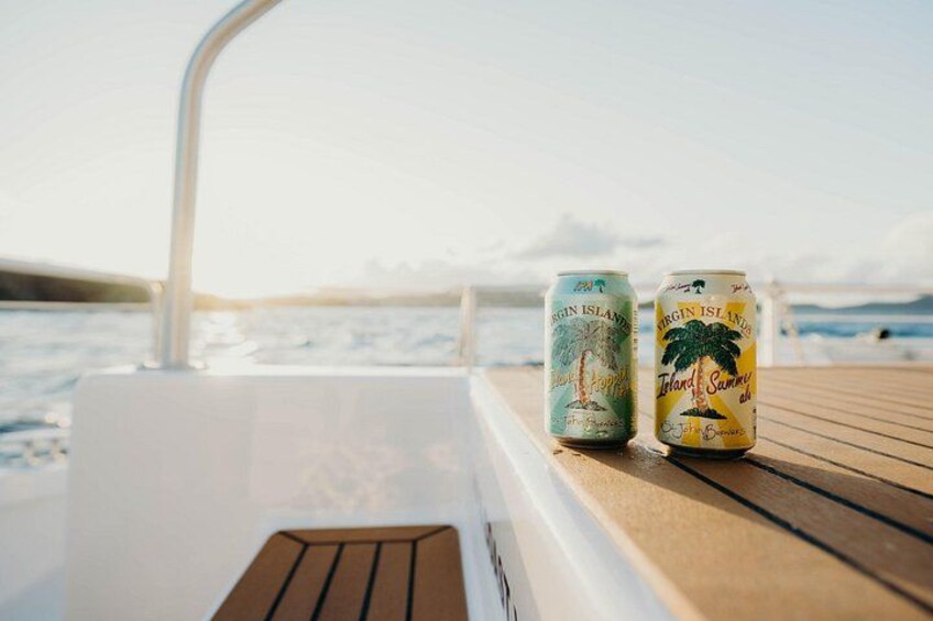 Two cans of Virgin Island beer on a boat deck with the ocean in the background. 2
