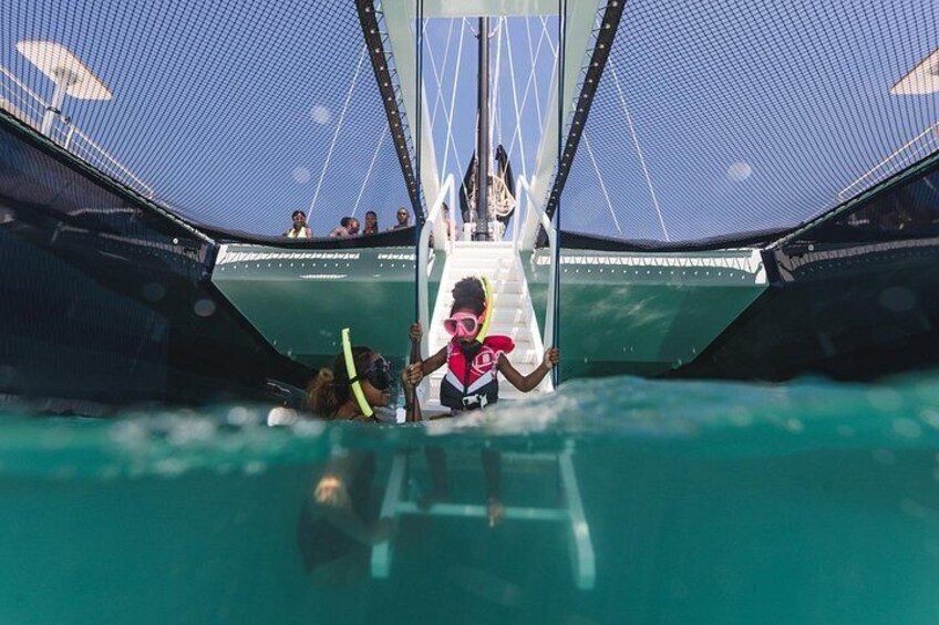 Una persona con chaleco salvavidas rosa y snorkel, a punto de entrar en un tobogán acuático. 3