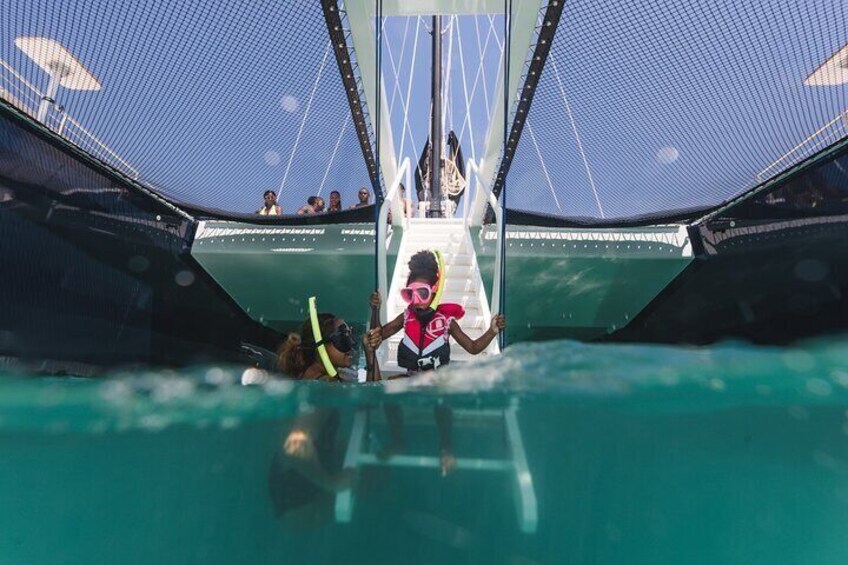 A person in a red life jacket and snorkel, preparing to enter a water structure. 4