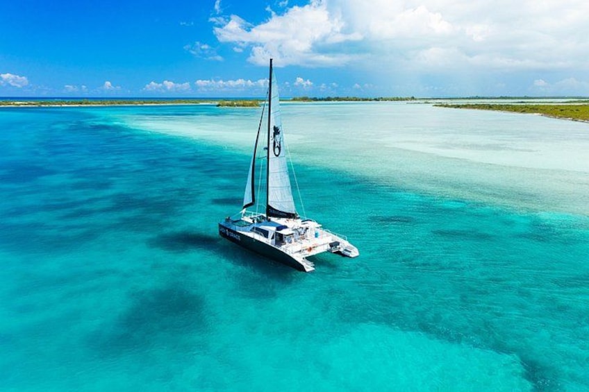 A sailboat on turquoise waters with a clear sky. 1