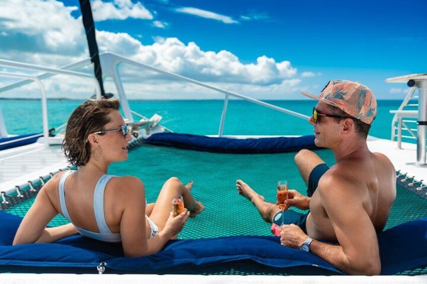 Two people relaxing on a boat deck with a view of the ocean. 3