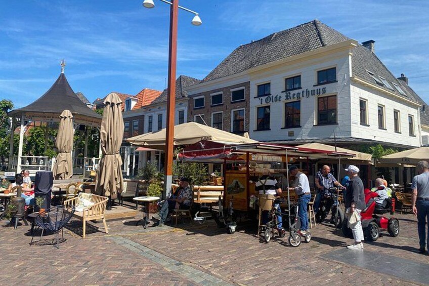 A bustling outdoor market with people, tables, and umbrellas. 2