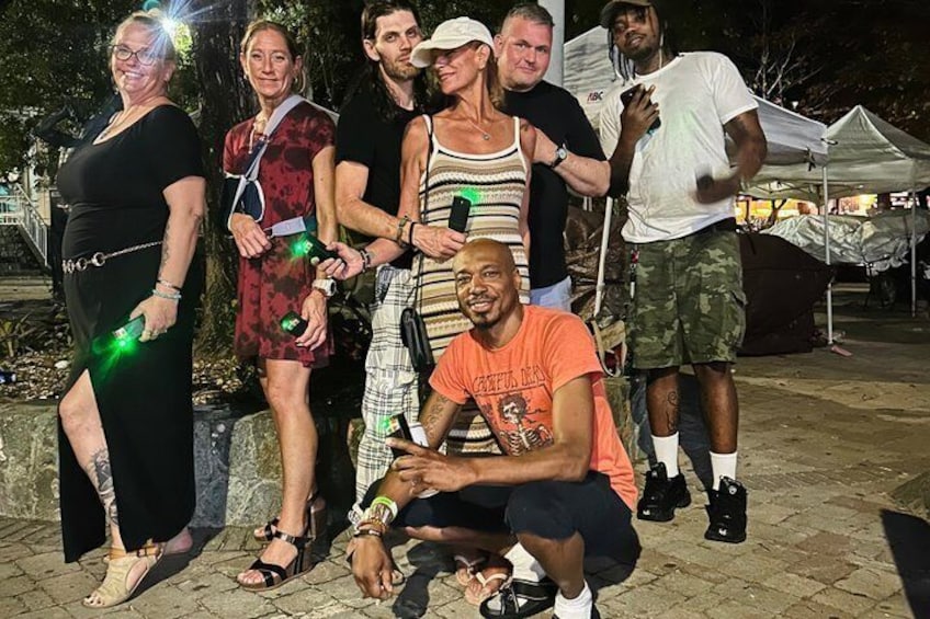 A group of people outdoors at night with artificial lighting. 3