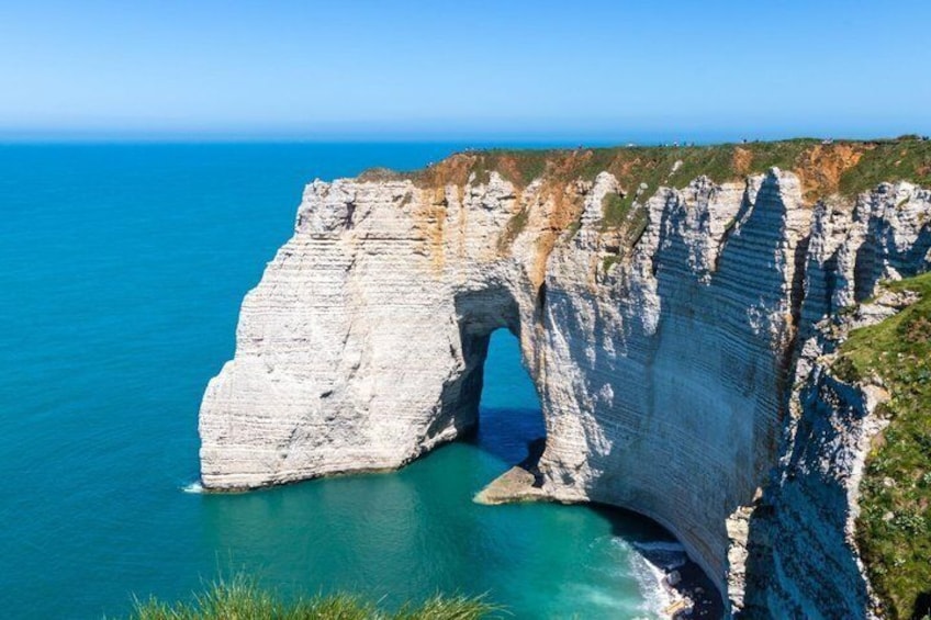 A coastal cliff with a natural arch formation. 2