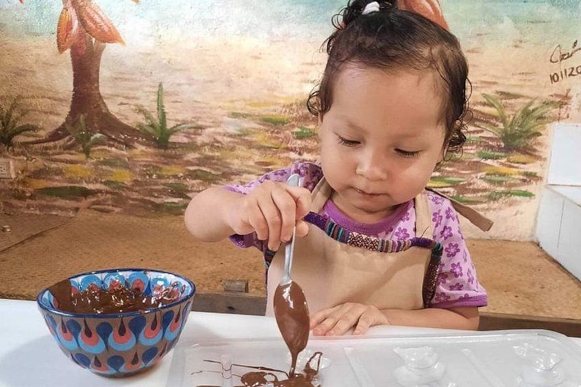 Un bambino seduto a tavola con una ciotola di cioccolato e un cucchiaio. 1