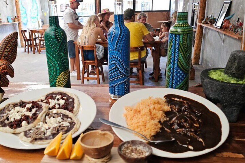 Un restaurante con coloridos jarrones, platos de comida y un mortero de piedra. 5