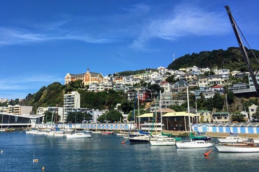 A harbor with boats, a bridge, and buildings on a hillside. 3