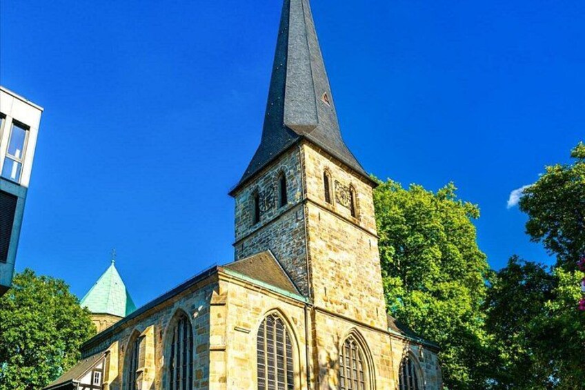 En kirke med et højt spir og buede vinduer. 2