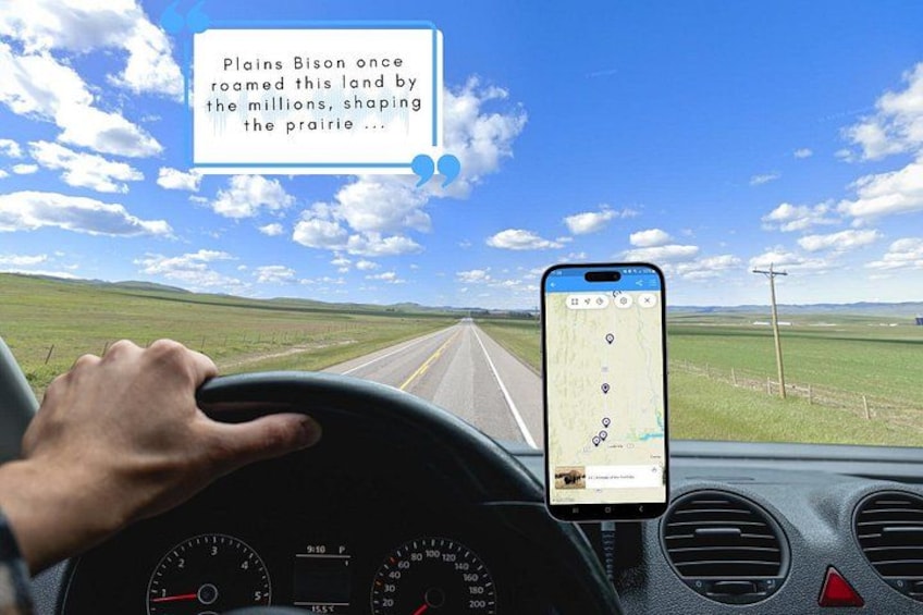 A hand on a steering wheel, a smartphone mounted on the dashboard, and a road ahead. 1