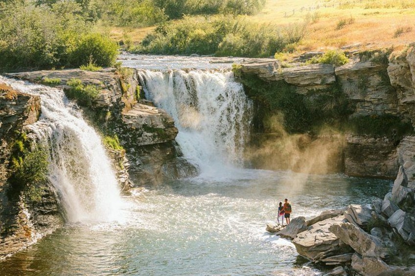 A waterfall cascading over rocky cliffs into a river. 3