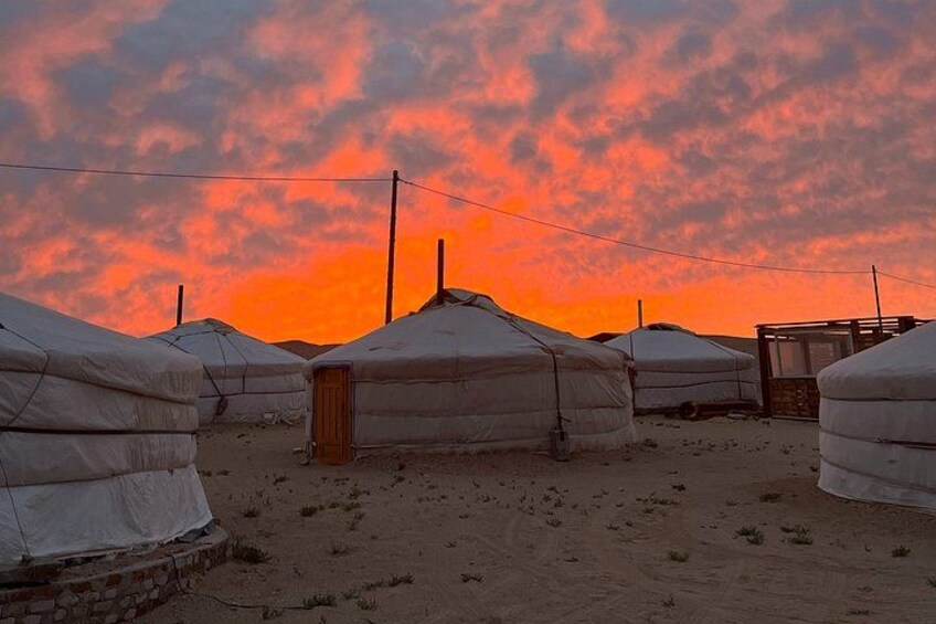Yurts in a desert landscape with a sunset sky. 3