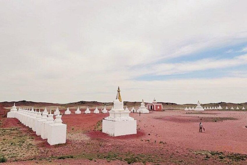 A series of white stupas in a desert landscape with a clear sky. 1