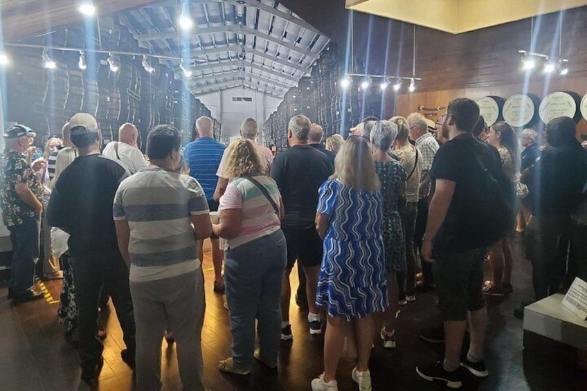 A group of people inside a building with a high ceiling and exposed beams. 1
