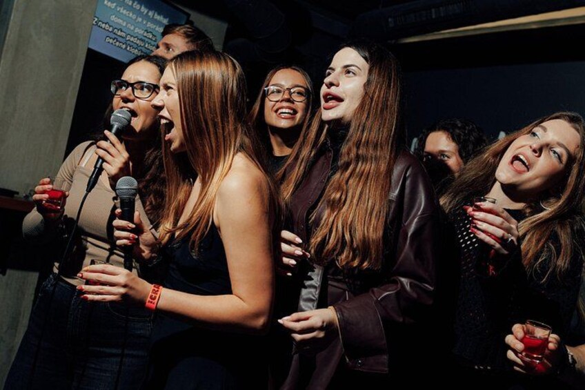 A group of people holding microphones, likely performing or speaking at an event. 2