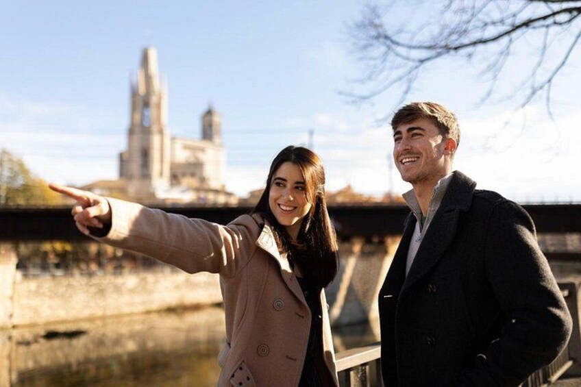 A person pointing towards a bridge with a tower in the background. 4