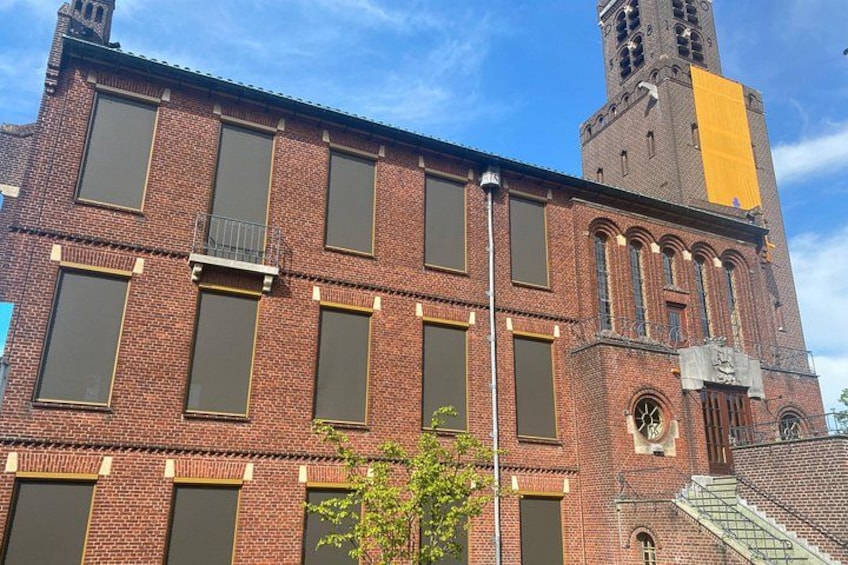 A red brick building with large windows and a clock tower. 4