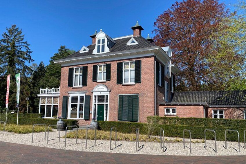 A large brick house with a white porch, green shutters, and a chimney. 4