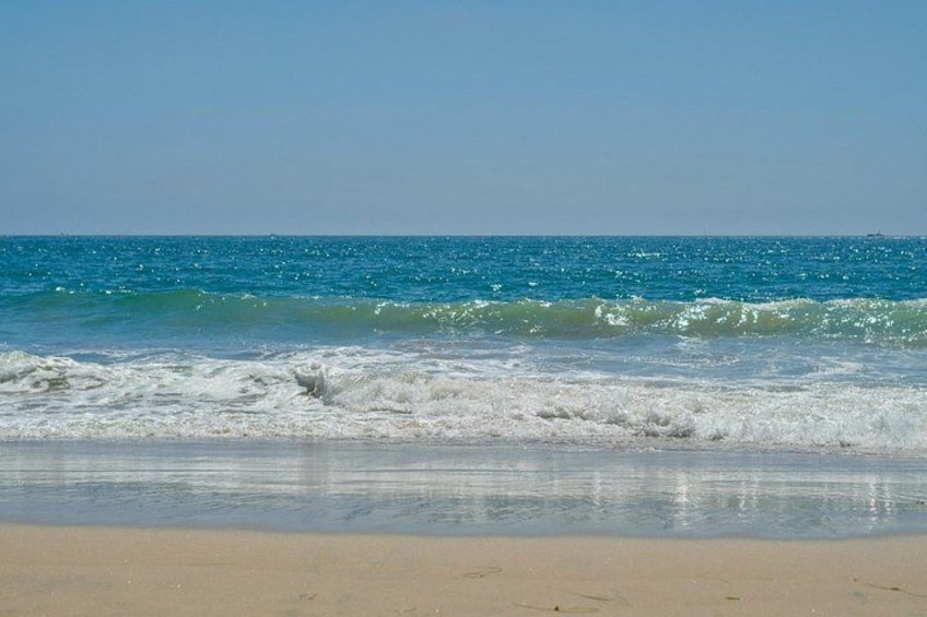 Une plage avec des vagues, un ciel dégagé et une mer calme. 2