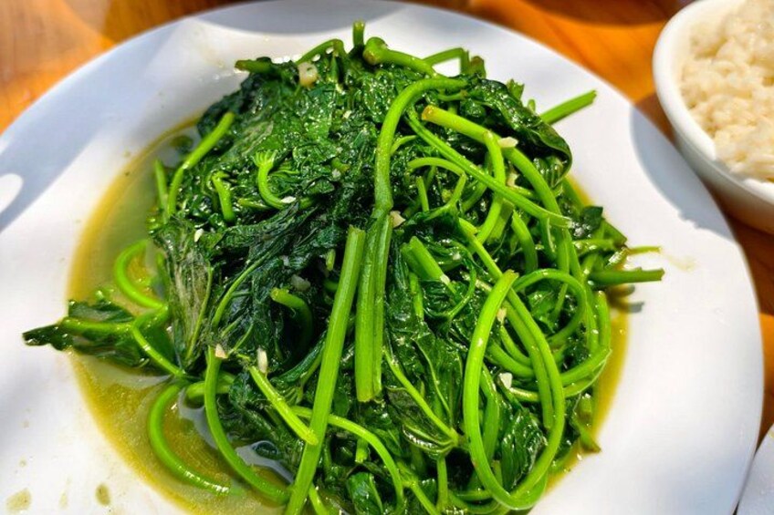 A plate of cooked leafy greens with a side of rice. 2