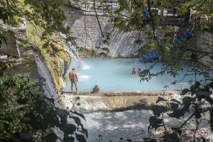 Een natuurlijke warmwaterbron, met mensen die zwemmen en ontspannen. 4