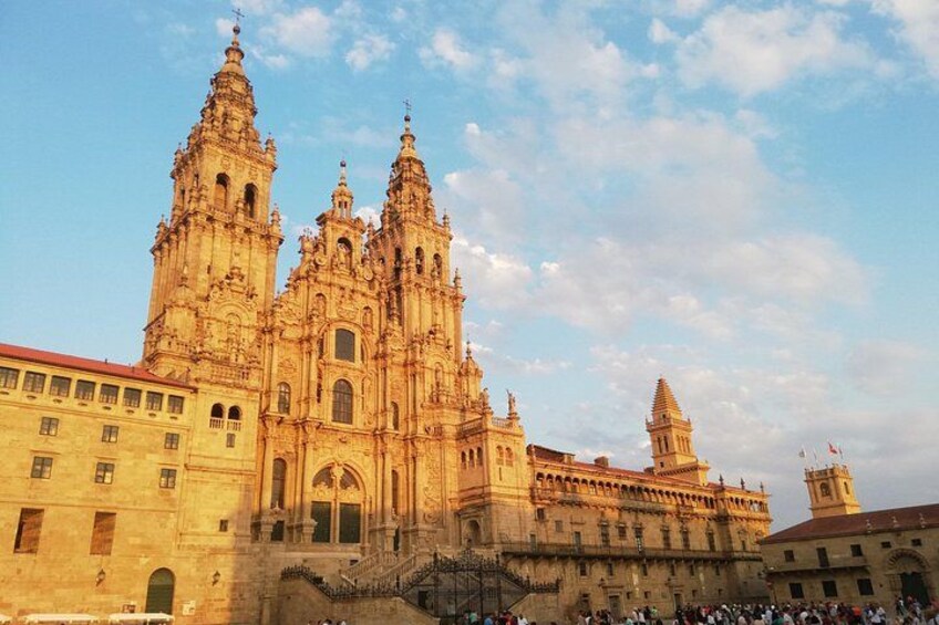 A large cathedral with two tall towers and a smaller tower, surrounded by a crowd. 1
