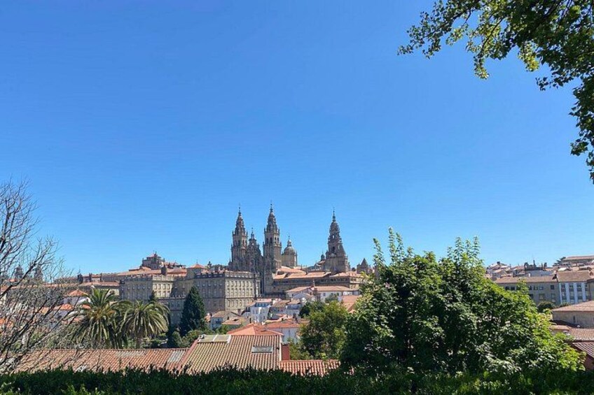 A historic building with multiple spires, surrounded by trees and other buildings. 2