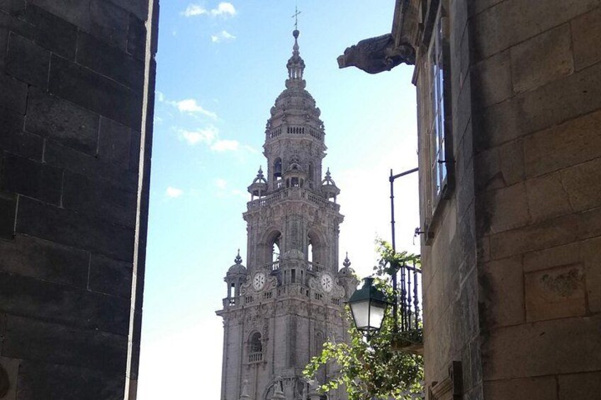 A historic church with a tall bell tower, a clock, and a statue. 5