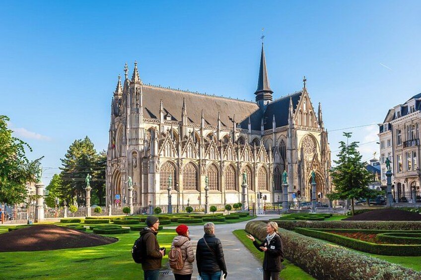 Una catedral histórica con detallada arquitectura gótica, rodeada de jardines cuidados y un cielo azul despejado. 3