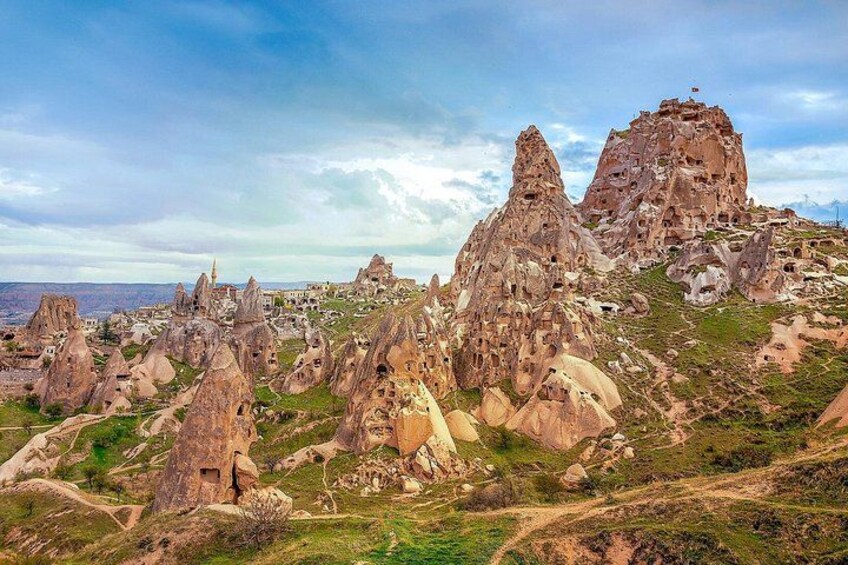 A landscape with unique rock formations and a mosque. 1