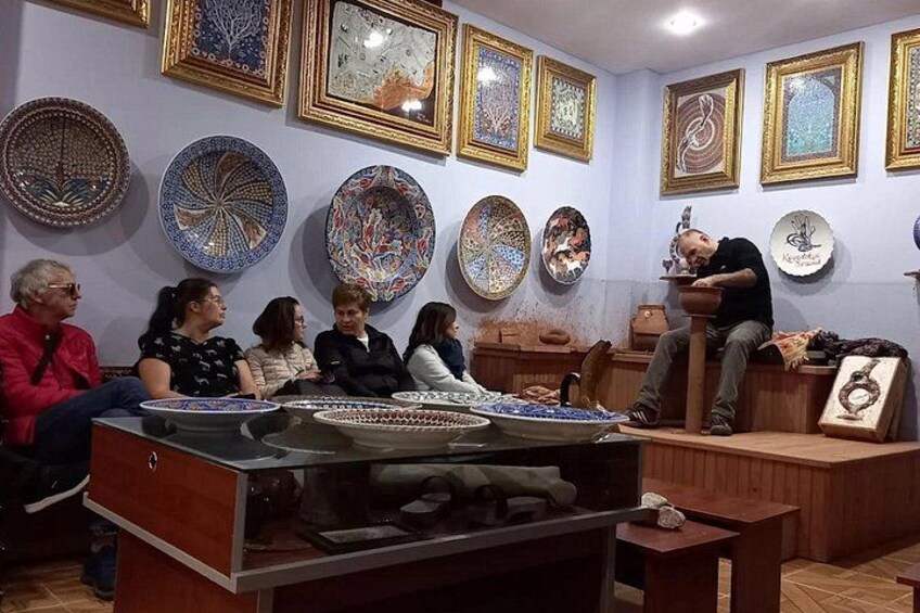 A group of people in a room with decorative plates on the wall. 3