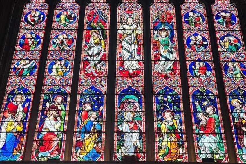 A stained glass window with religious figures and scenes. 3
