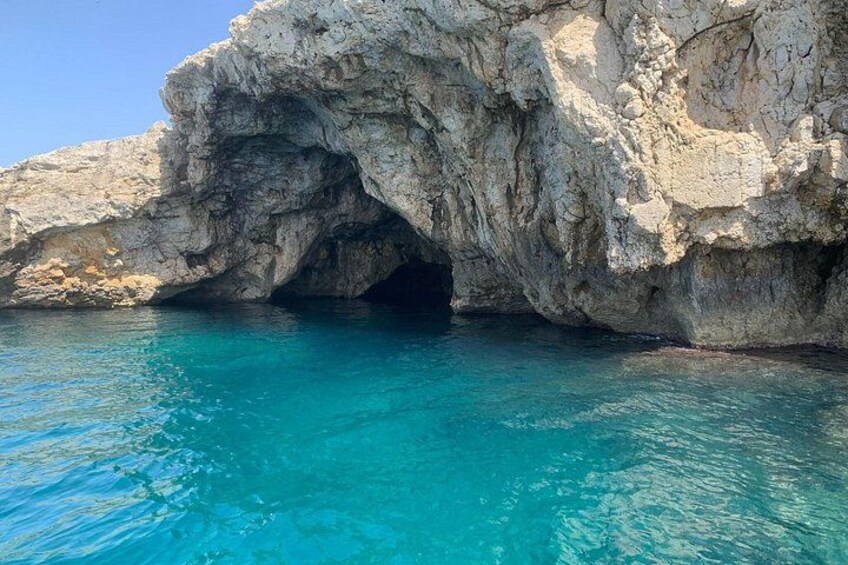 La entrada rocosa a una cueva con agua azul cristalina. 2