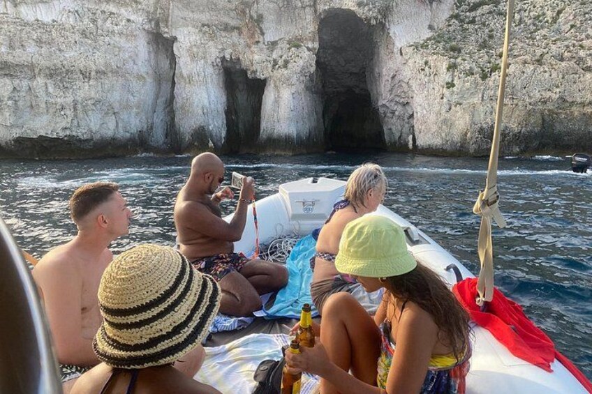 Un grupo de personas en un bote cerca de acantilados rocosos. 1