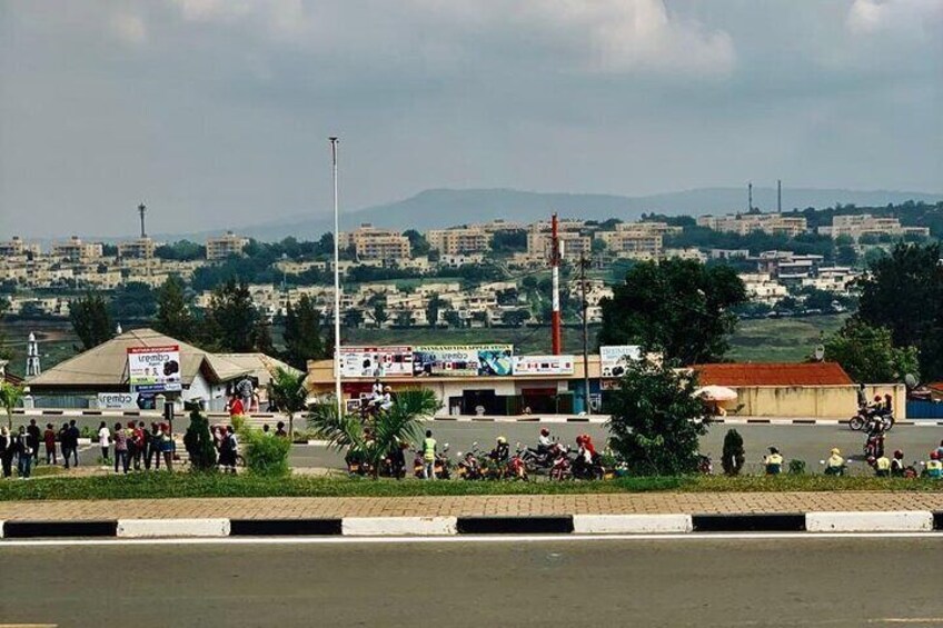 Une rue animée, avec une foule de personnes, quelques motos et des bâtiments en arrière-plan. 3