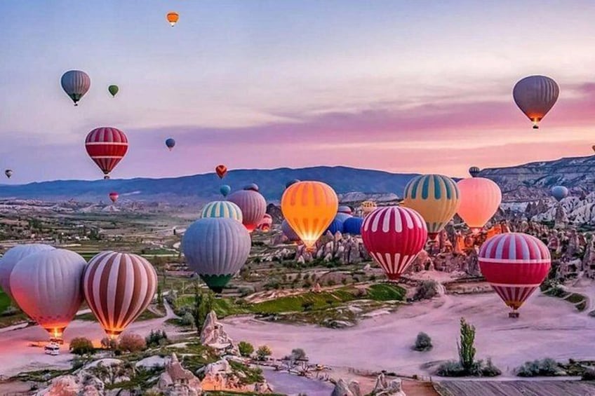 A landscape with numerous hot air balloons in various colors. 1